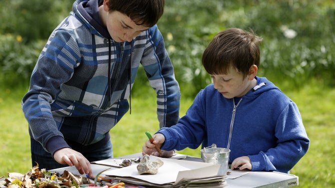 Children creating art from leaves, twigs and bark, in the grounds at Mottisfont, Hampshire